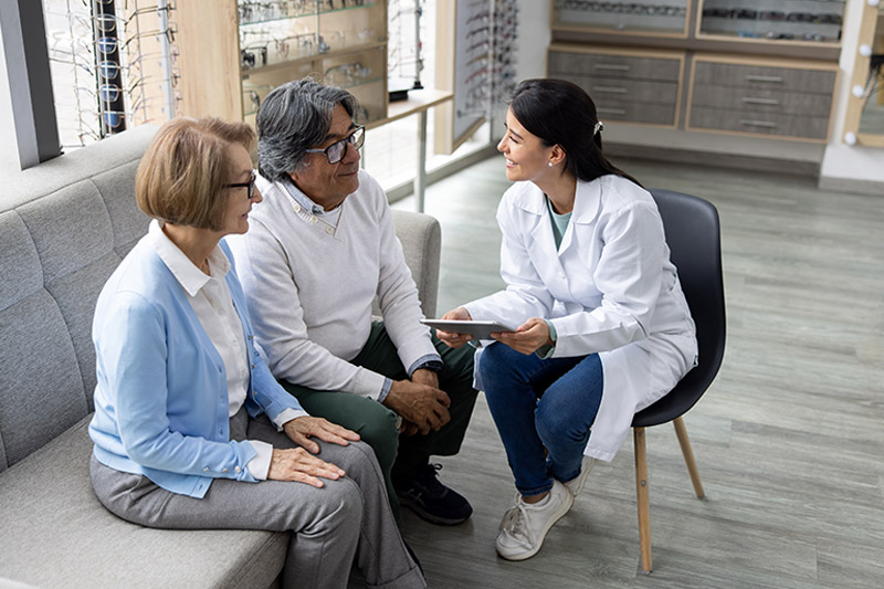 eye doctor meeting with two patients