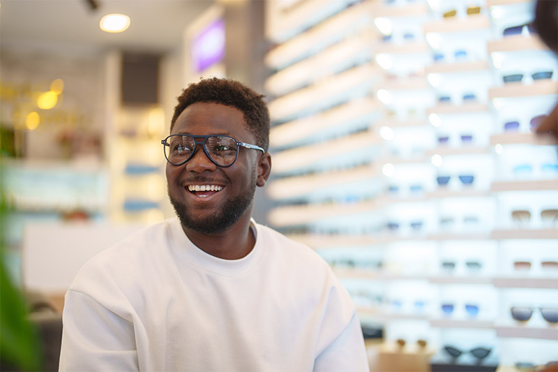 man trying on glasses at eye doctor
