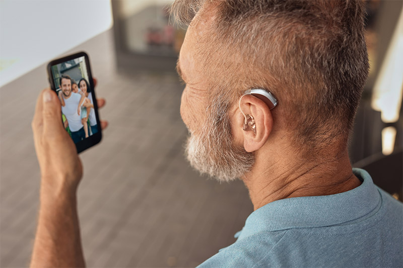 man using a hearing aid while on a video call