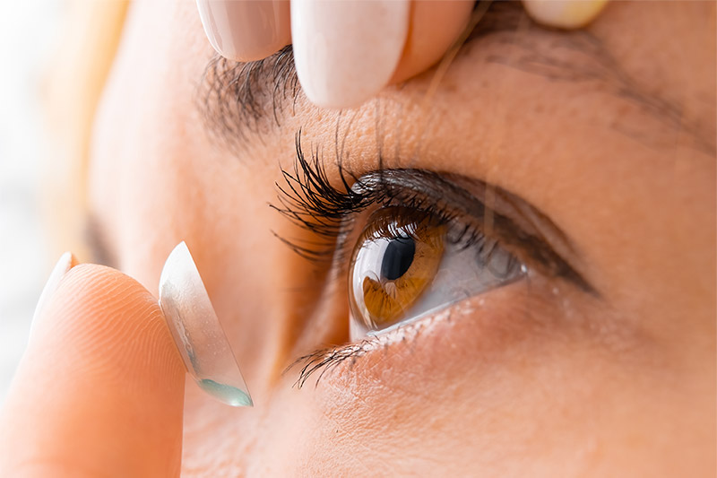 close up of person putting in contact lens