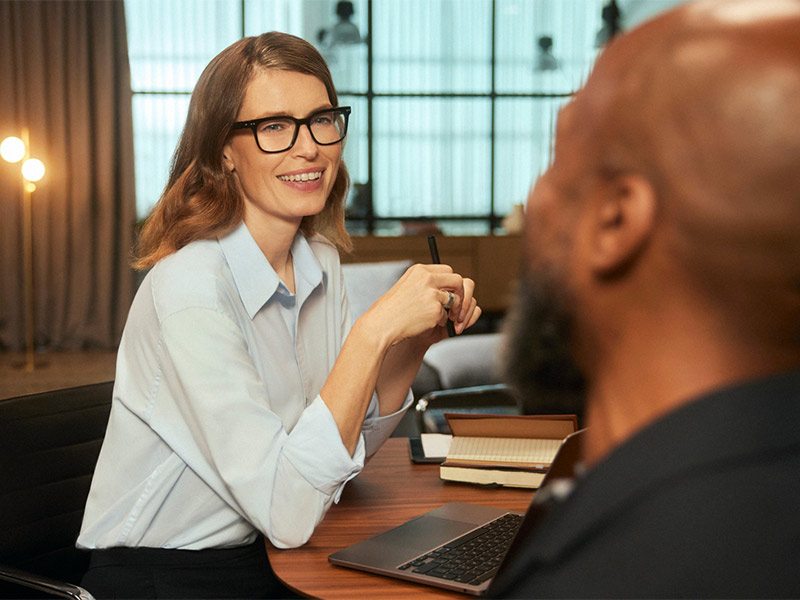 Person wearing glasses in a meeting at a table